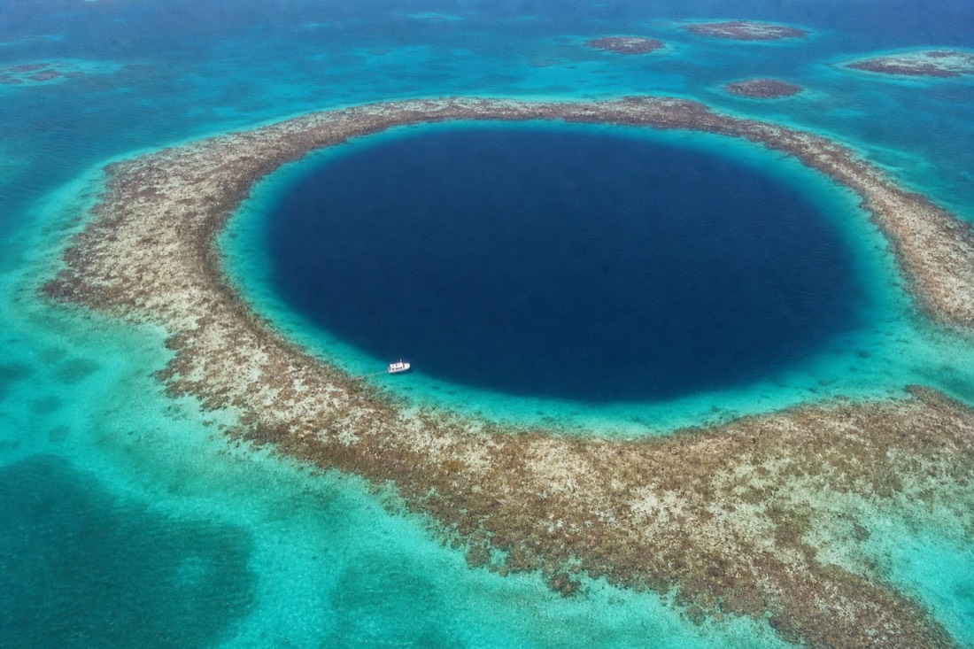 The Great Blue Hole seen from above within Lighthouse Reef Atoll, an area known for the best snorkeling in Belize