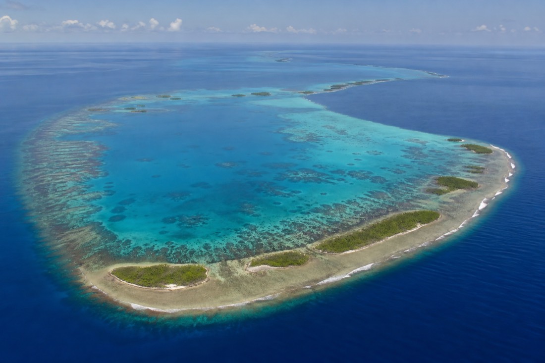Turneffe Atoll from above, a ring-shaped reef offshore of the barrier with a mangrove-filled lagoon visited on snorkeling tours in Belize