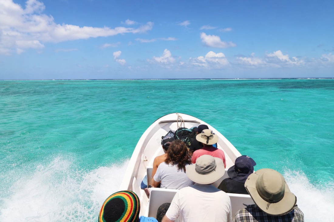 Speedboat crossing open water toward the Belize Barrier Reef on a Blue Hole Belize snorkel trip